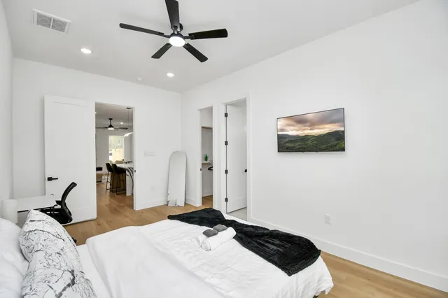 a bedroom with a bed and wooden floor