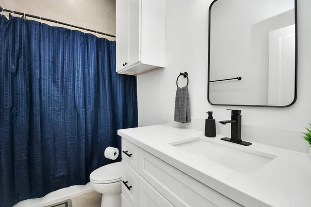 a bedroom with a bed and flat tv screen on the dresser