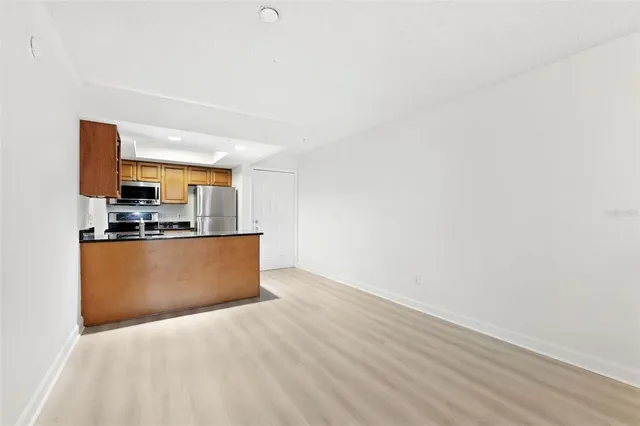 a view of kitchen with stainless steel appliances wooden floor