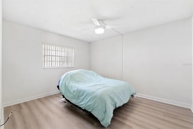 an empty room with windows and fan