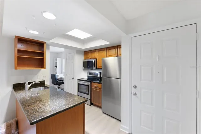 a kitchen with stainless steel appliances granite countertop a sink refrigerator and microwave