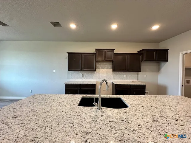 a kitchen with stainless steel appliances kitchen island microwave and sink