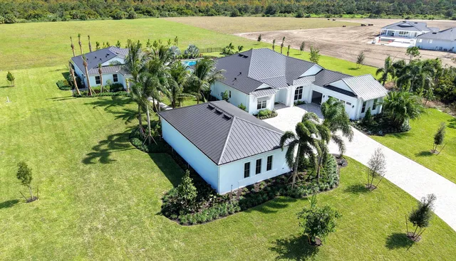 an aerial view of a house with a garden and lake view