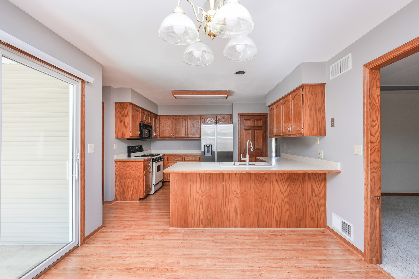 304 Andrea Drive Manhattan, IL 60442 - Photo 31 of 53 a large white kitchen with wooden floor