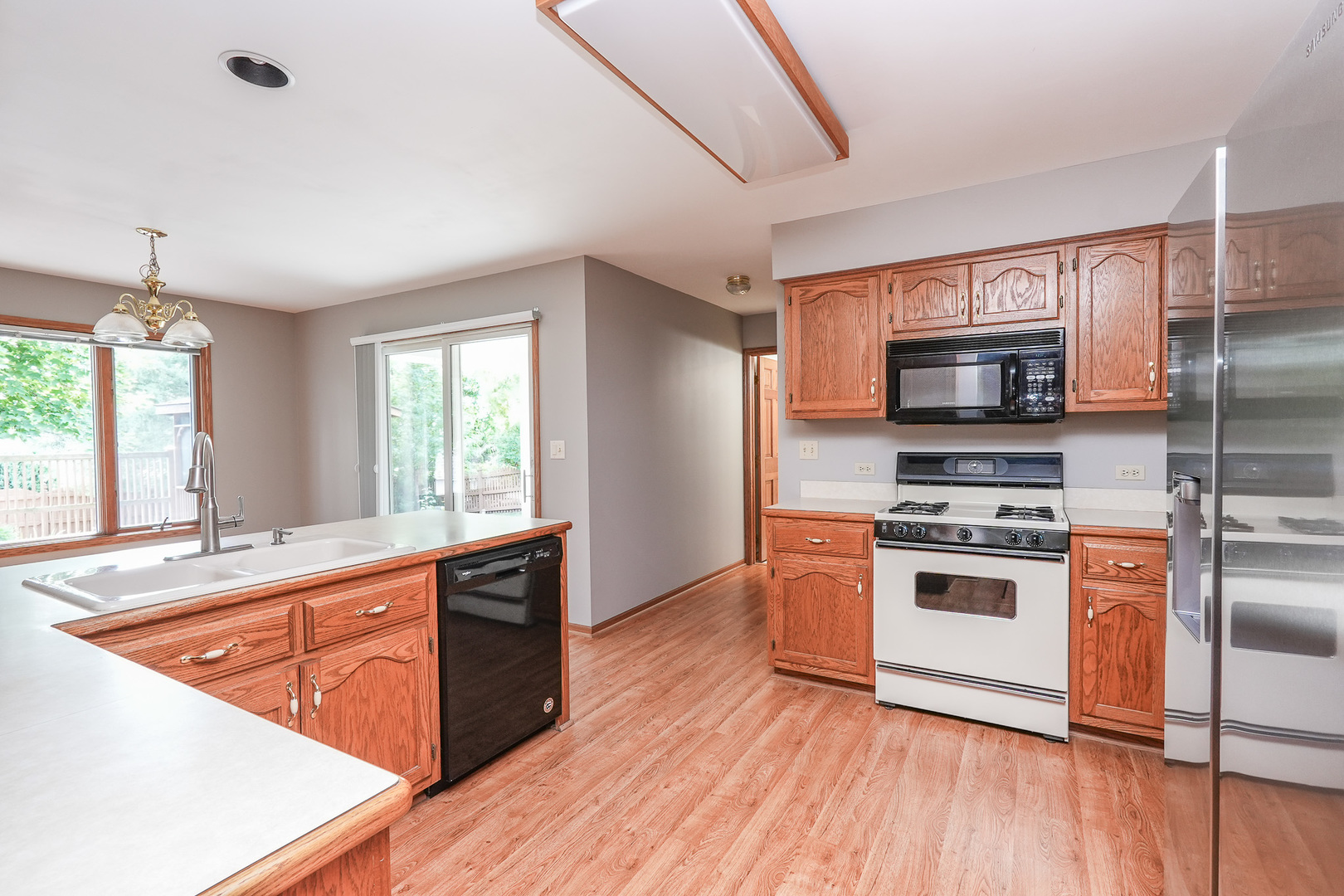 304 Andrea Drive Manhattan, IL 60442 - Photo 36 of 53 a kitchen with stainless steel appliances granite countertop a stove a sink and a refrigerator