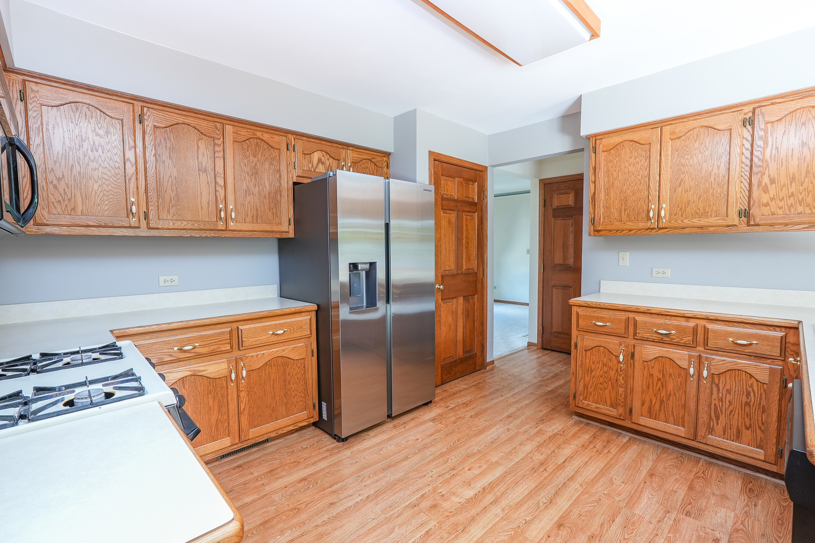 304 Andrea Drive Manhattan, IL 60442 - Photo 37 of 53 a kitchen with stainless steel appliances granite countertop a refrigerator a stove a sink and dishwasher with wooden floor