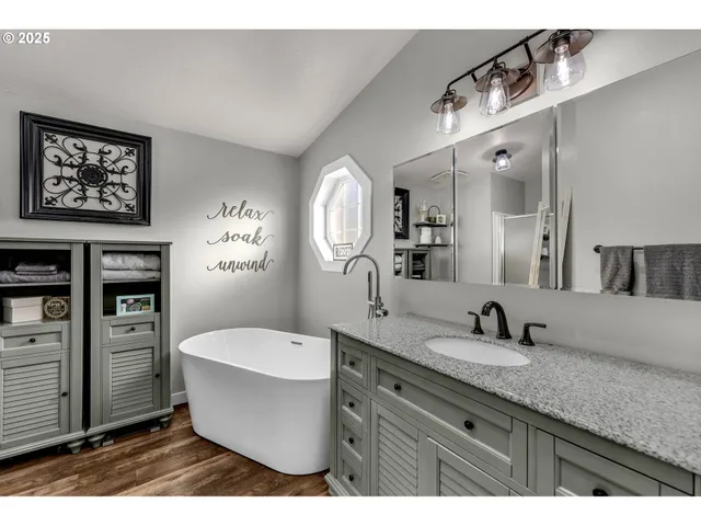 a spacious bathroom with a tub sink and mirror