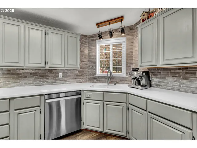 a kitchen with stainless steel appliances granite countertop a sink a stove a microwave and cabinets