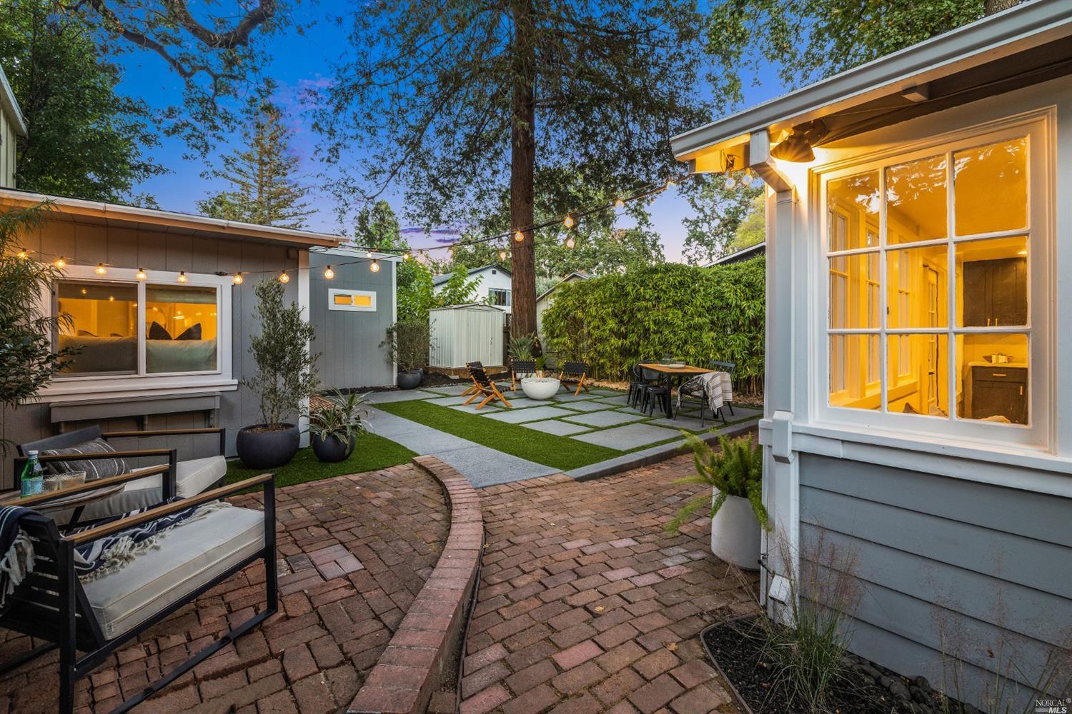 a backyard of a house with barbeque oven table and chairs