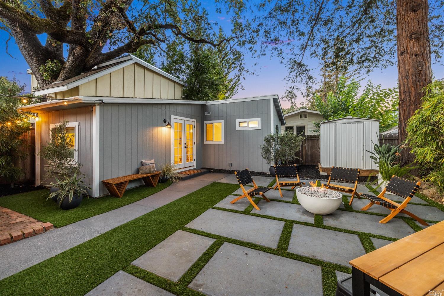 27 Laurel Avenue San Anselmo, CA 94960 - Photo 37 of 52 a view of a patio with table and chairs and a barbeque with potted plants and a large tree