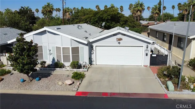 a view of a white house with a outdoor space and parking space
