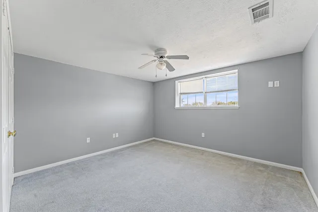 a view of a room with a ceiling fan and a window