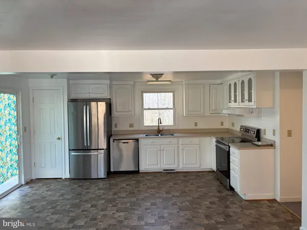 a kitchen with granite countertop a refrigerator stove top oven and sink