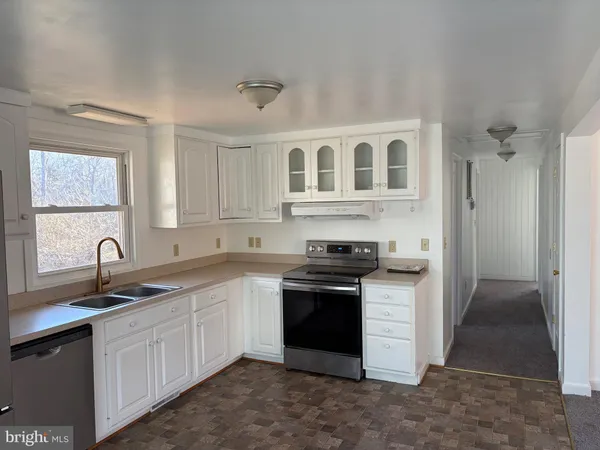 a kitchen with cabinets appliances and a sink