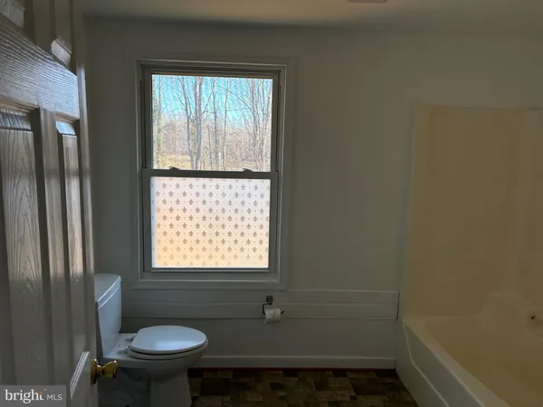 a bathroom with a sink window and a toilet