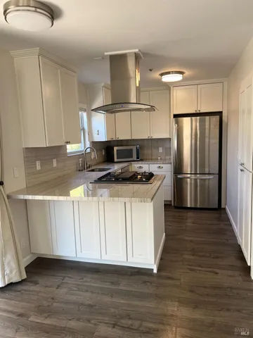 a kitchen with stainless steel appliances granite countertop a stove a sink and a refrigerator