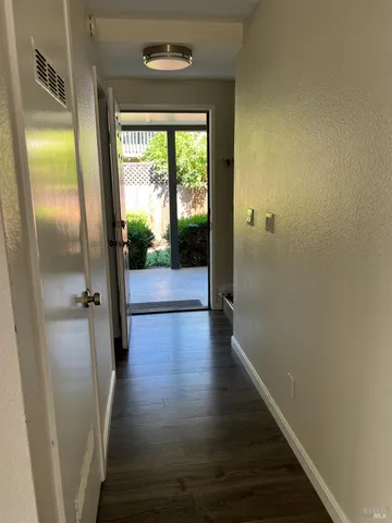 a view of a hallway with wooden floor