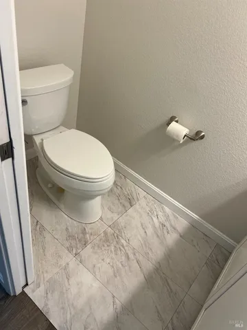 a white toilet sitting next to a shower