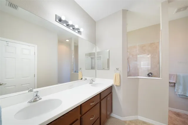 a bathroom with a sink double vanity and a mirror
