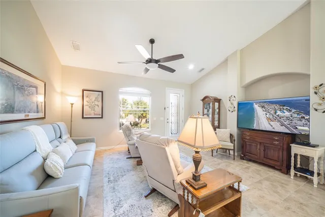 a living room with furniture a rug and wall paintings