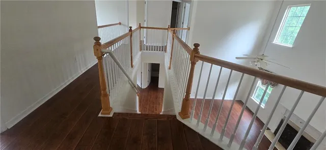 a view of staircase with railing and white walls