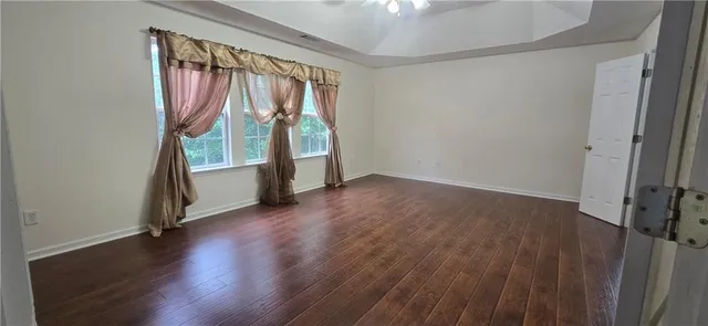an empty room with wooden floor and door