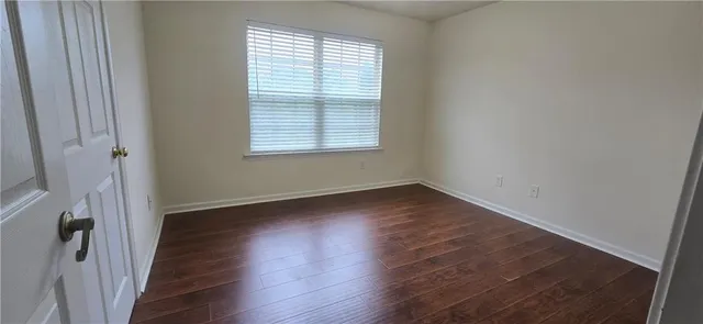 an empty room with wooden floor and a window