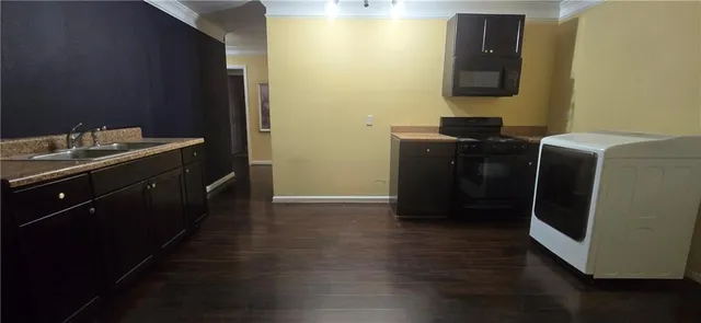 a kitchen with a refrigerator and a stove top oven