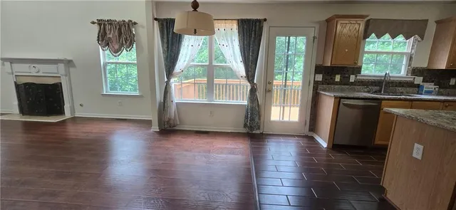 an empty room with wooden floor and a fireplace