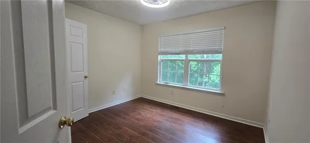 a view of a room that has wooden floor and a window