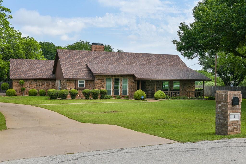 a front view of a house with a garden and trees