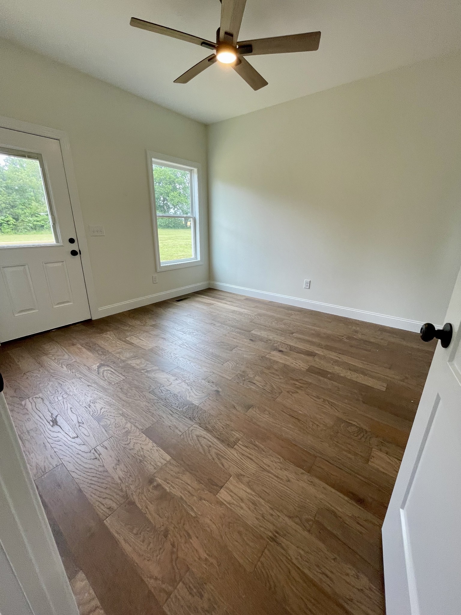 58 Union Hill Road Loretto, TN 38469 - Photo 4 of 13 an empty room with wooden floor fan and windows