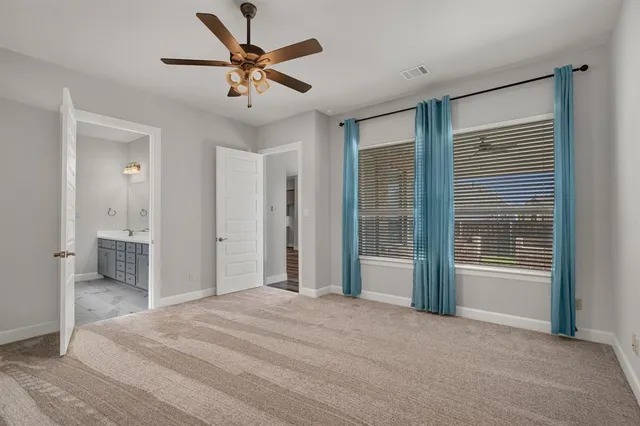 a view of a room with a ceiling fan closet and a large window
