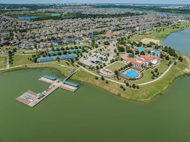 an aerial view of ocean and residential houses with outdoor space