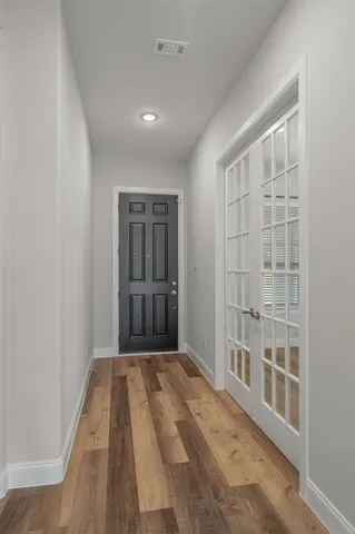 a view of a bedroom with wooden floor and a window