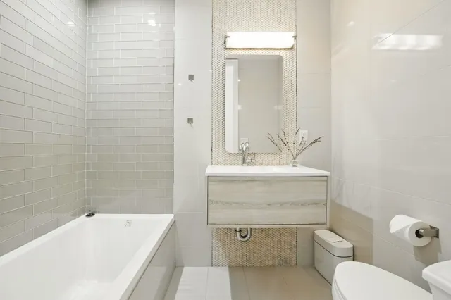a bathroom with a toilet sink and mirror