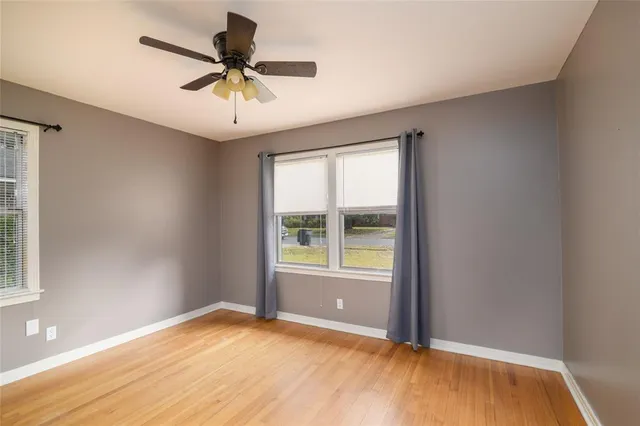 an empty room with a window and a ceiling fan