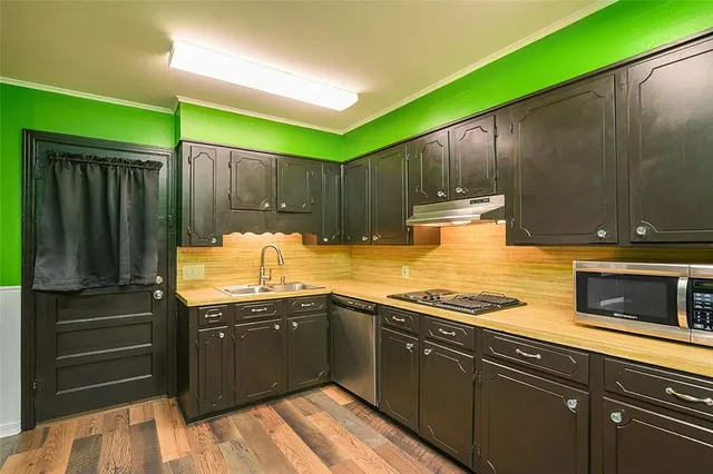 a kitchen with sink cabinets and stove top oven