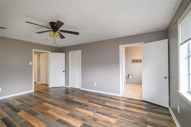 a view of room with wooden floor and ceiling fan