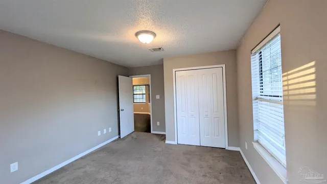 an empty room with windows and closet