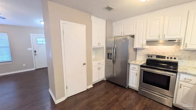 a kitchen with a refrigerator stove and wooden cabinets