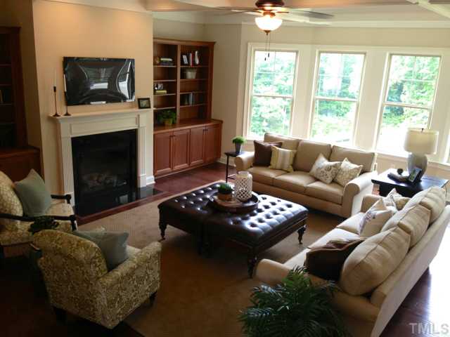 5108 Accabonac Point Raleigh, NC 27612 - Photo 3 of 25 with gorgeous window wall, coffered ceiling and handsome bookshelves that flank gas fireplace