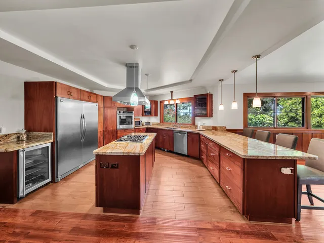 a kitchen with stainless steel appliances granite countertop wooden floors and sink