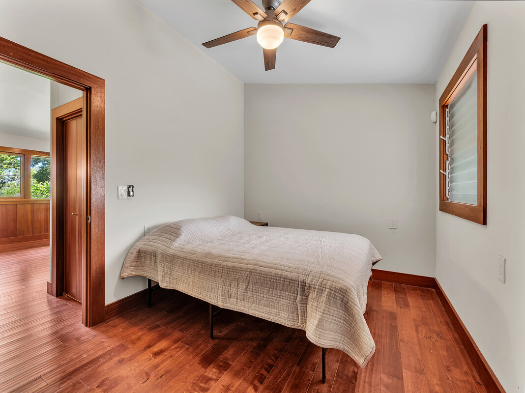 46 Kokea Street Hilo, HI 96720 - Photo 20 of 29 a bedroom with a bed and wooden floor