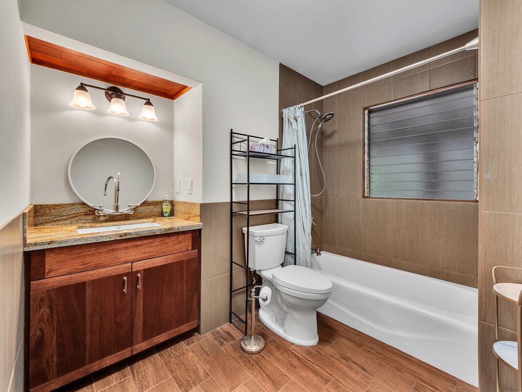 46 Kokea Street Hilo, HI 96720 - Photo 21 of 29 a bathroom with a granite countertop toilet a sink and a mirror
