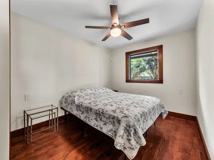 a bedroom with bed window and wooden floor