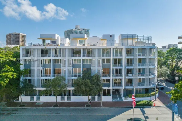 a large building with a lot of plants in front of it