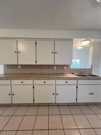 a kitchen with granite countertop white cabinets and white appliances