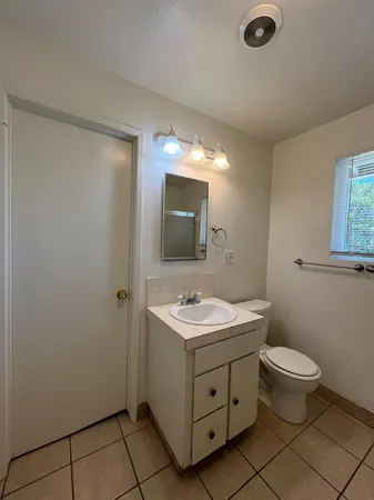 a bathroom with a toilet sink and mirror