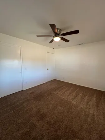 en empty room with ceiling fan and window